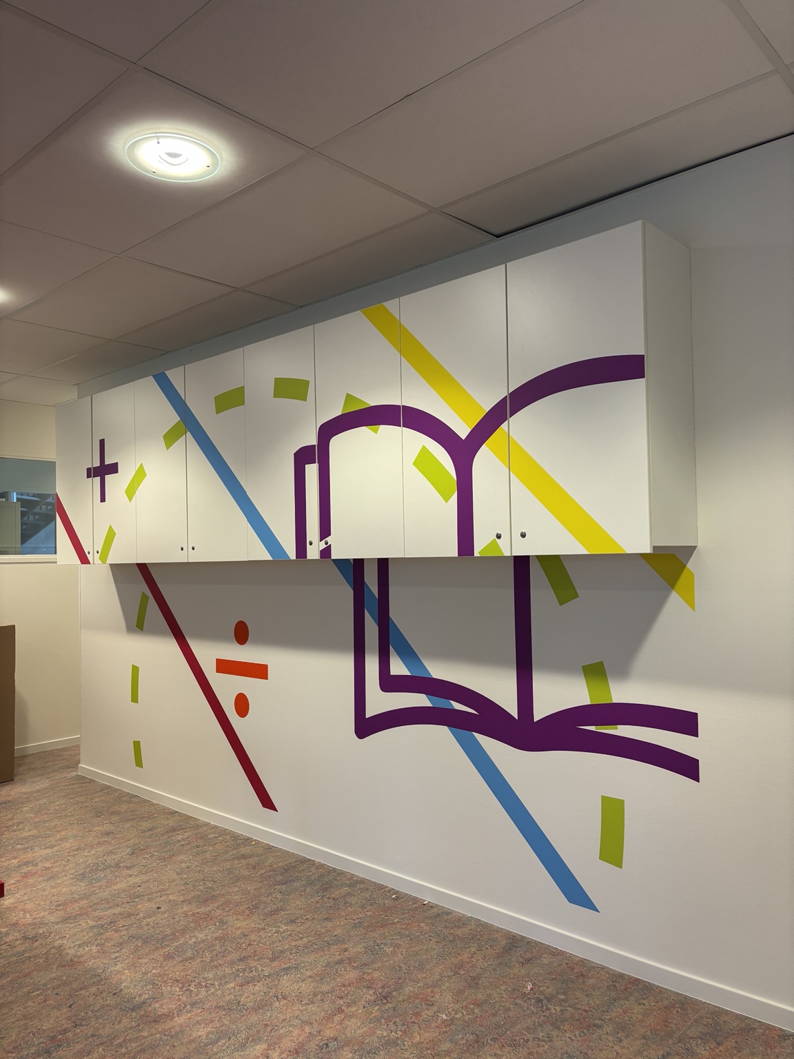 Bestaande kastenwand met doorlopende kleurrijke sportstriping en grafische vormen