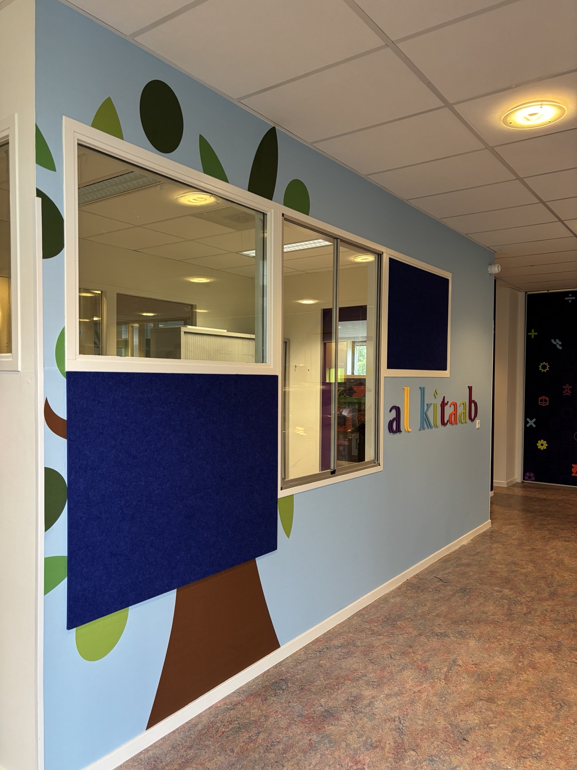 Al Kitaab-logo en grotere gekleurde elementen uitgevoerd in PET-vilt